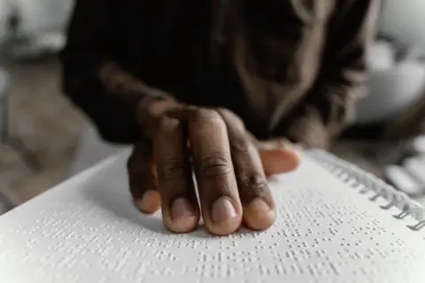 close-up-hand-reading-braille