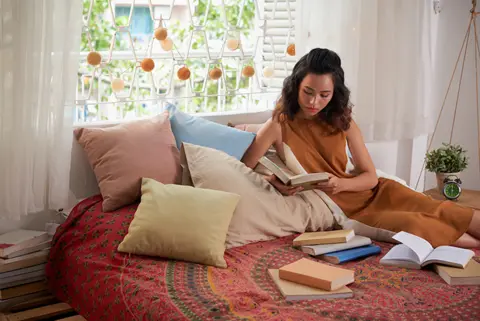 portrait-teen-girl-reading-text-books-her-bed